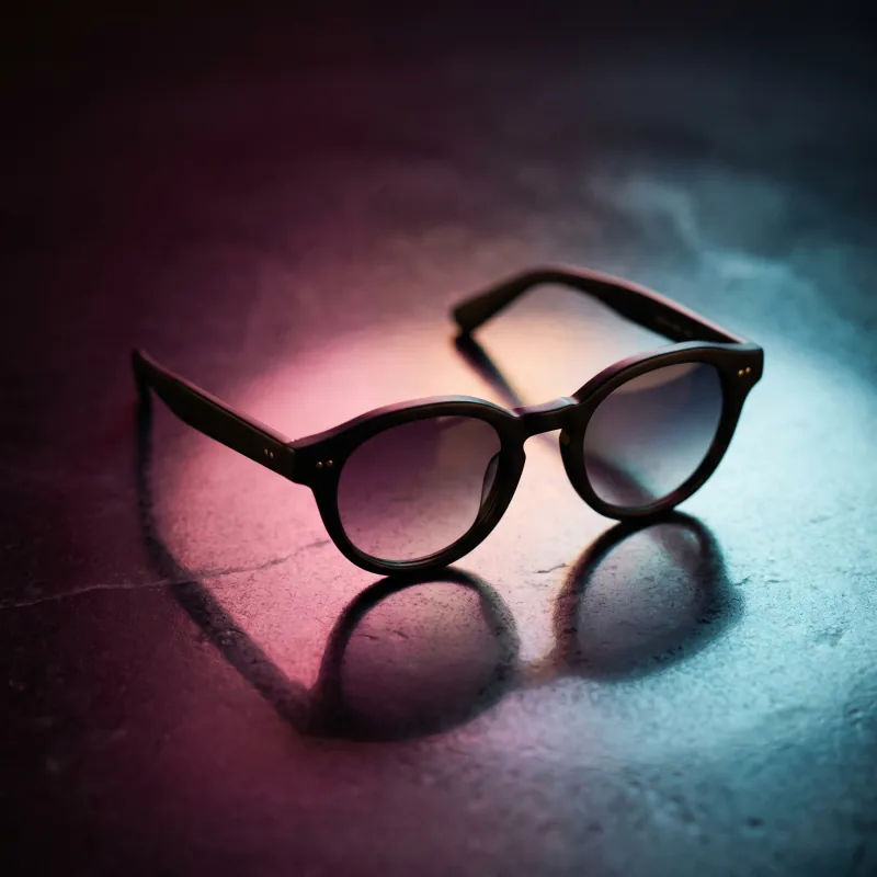 Sunglasses under a pink and blue gradient light